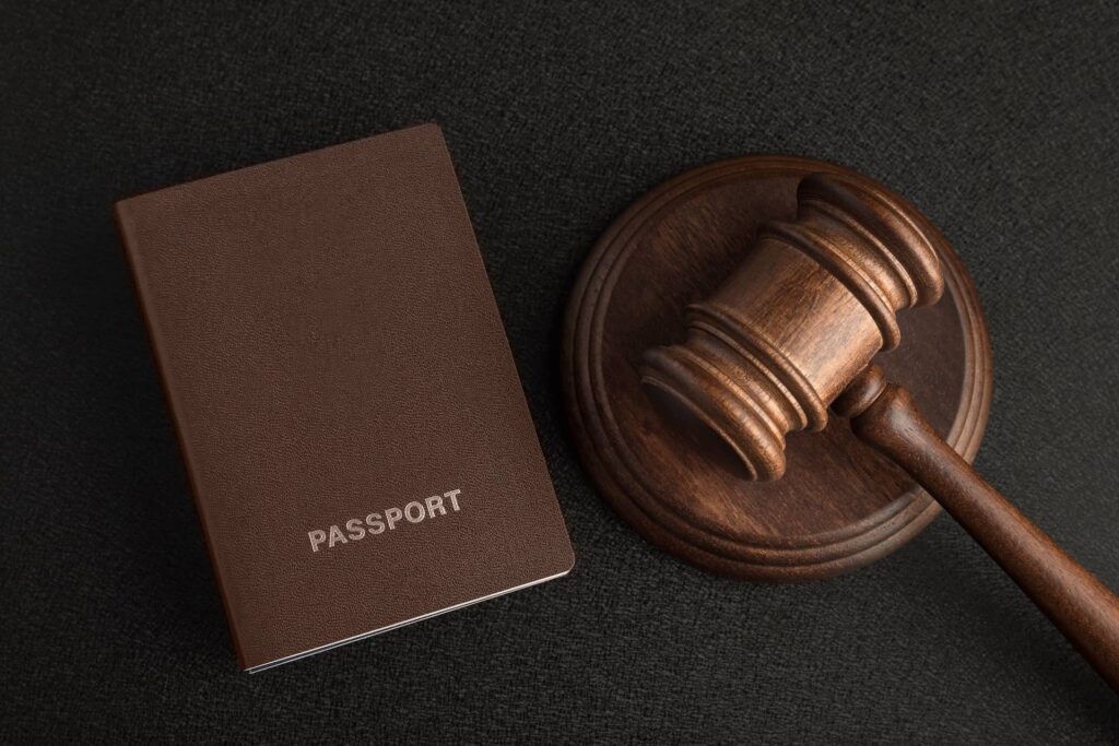 Passport and judge gavel on gray black background. Legal