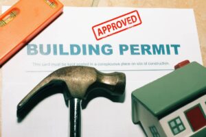 Building dreams into reality: an approved license with a hammer and model house, signaling the green light for property legalizations to begin.